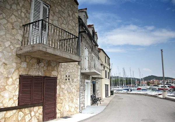 Gamla gatan av stenhus med bänk vid havet — Stockfoto