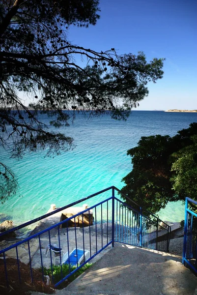 Лестницы на пляж, чистая вода и голубое небо в Хорватии Далмация — стоковое фото