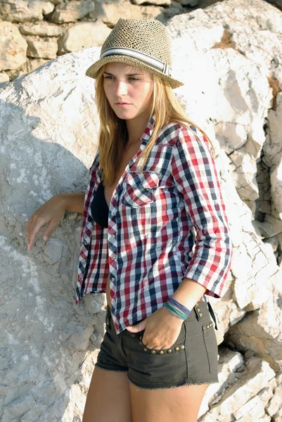 Mujer joven posando frente a la pared de piedra — Foto de Stock