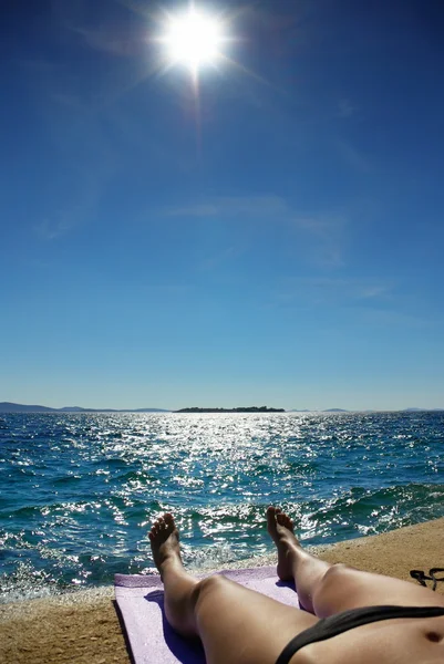 Corps de jeune femme, bronzage sur une plage — Photo