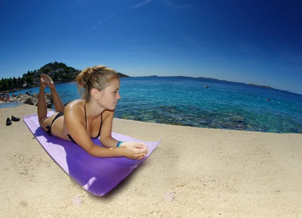 Young woman, sunbathing on a beach — Stock Photo, Image