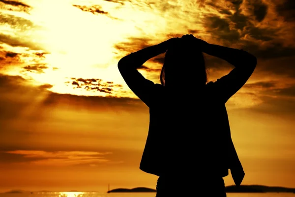 Silueta mujer y puesta de sol en la playa — Foto de Stock