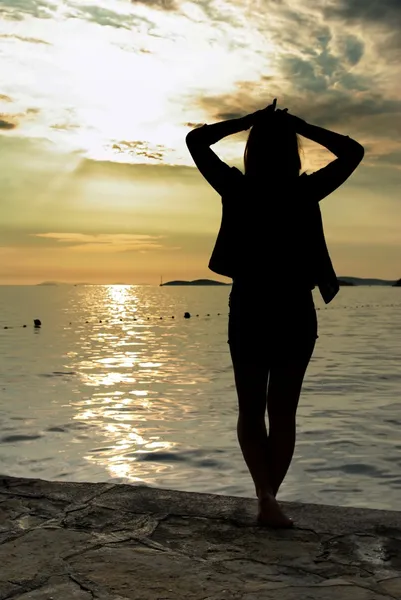 Γυναίκα σιλουέτα και ηλιοβασίλεμα στην παραλία — Φωτογραφία Αρχείου