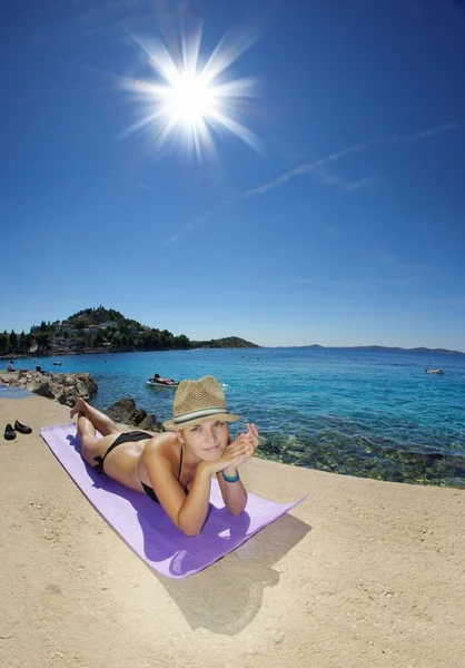 Молода жінка в солом'яному капелюсі купається на пляжі — стокове фото