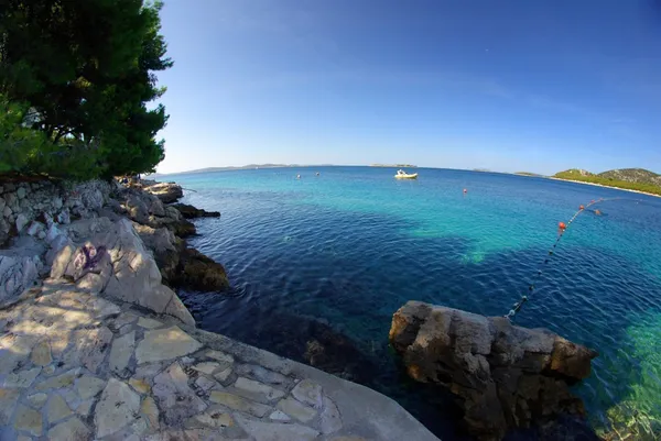 Praia rochosa na baía mar azul-turquesa, Croácia Dalmácia — Fotografia de Stock
