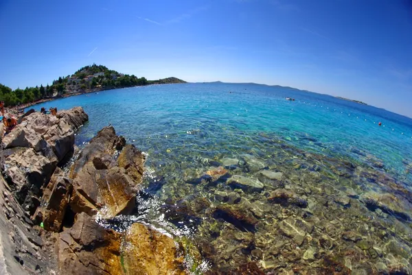 Playa rocosa en la bahía de mar turquesa, Croacia Dalmacia —  Fotos de Stock