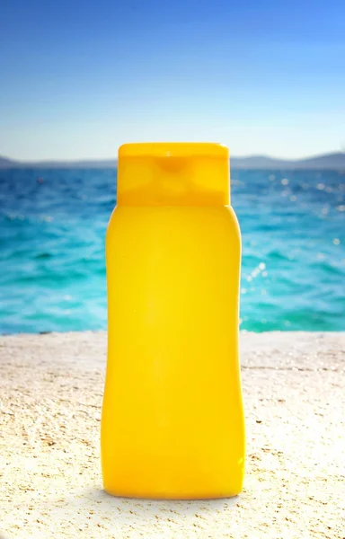 Banho de sol - creme bronzeado do sol ou óleo na praia — Fotografia de Stock