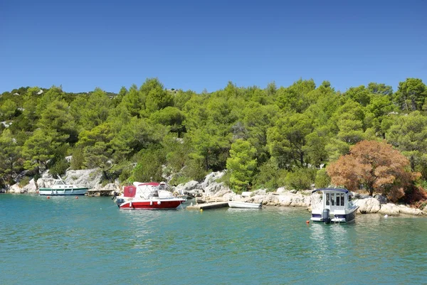 Liten båt förtöjd till den klippiga kusten av havet bay, Kroatien Dalmatien — Stockfoto