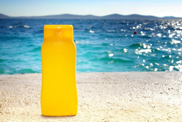 Сонячні ванни - бобові вершки або олія на пляжі — стокове фото