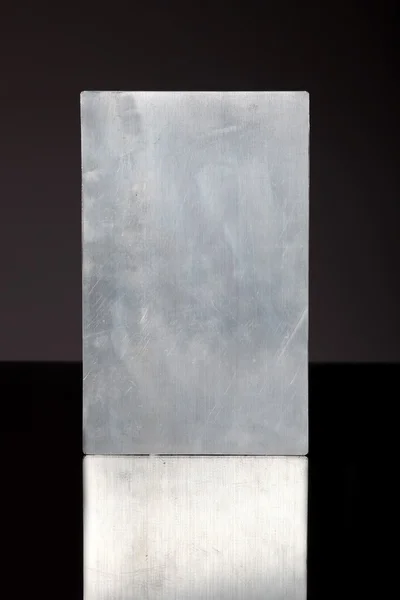 Metal plate, texture or empty frame reflected in dark surface — 图库照片