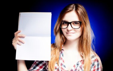 Happy young girl with nerd glasses holding exercise book clipart