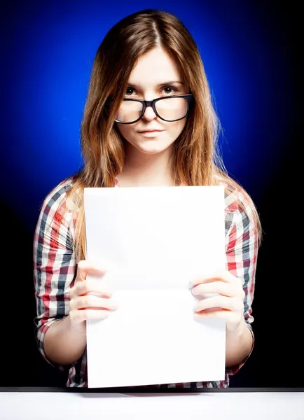 Chica joven con libro de ejercicios mirando a través de las gafas nerd —  Fotos de Stock