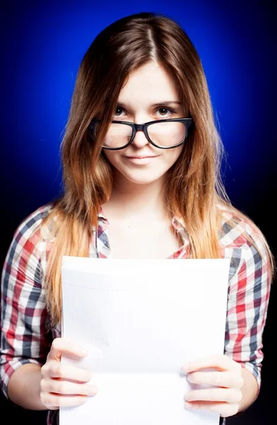 Chica joven con libro de ejercicios mirando a través de las gafas nerd —  Fotos de Stock