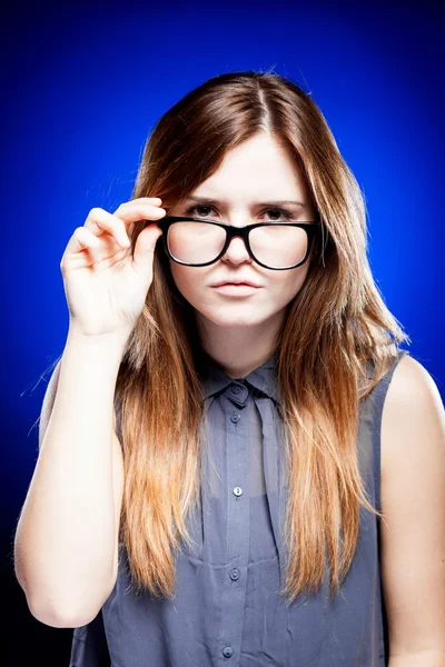 Mujer joven mirando a través de las gafas nerd — Foto de Stock