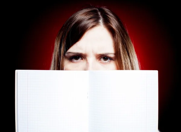 Disappointed and angry young girl holding exercise book — Stock Photo, Image