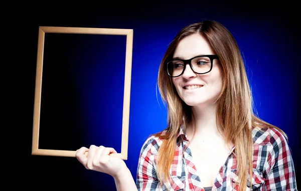 Mujer sonriente con gafas nerd sosteniendo marco —  Fotos de Stock