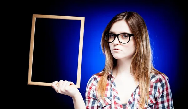 Woman with nerd glasses holding wooden frame — Stock Photo, Image