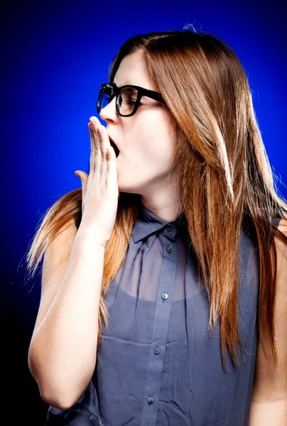 Gelangweilte junge Frau mit Nerd-Brille gähnt — Stockfoto