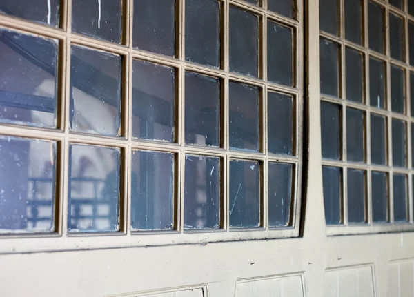 Stare zaniedbane drzwi drewniane z małych okienek — Zdjęcie stockowe