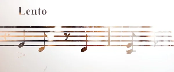Музыкальные ноты на матовом стекле, художественном фоне — стоковое фото