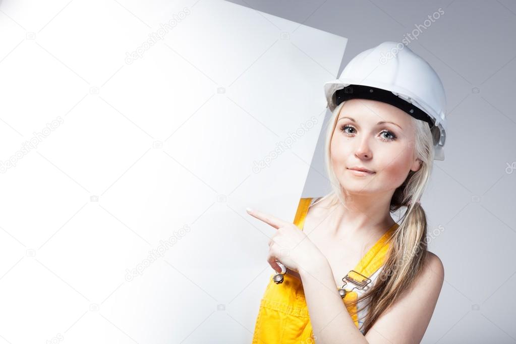 Young builder woman construction worker, empty banner