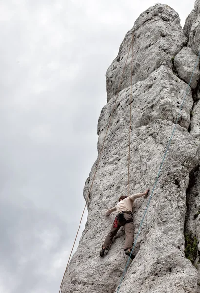 Joven escalando en la pared de piedra caliza — Foto de Stock