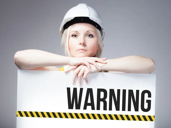 Worker holding warning sign on information board — Stock Photo, Image