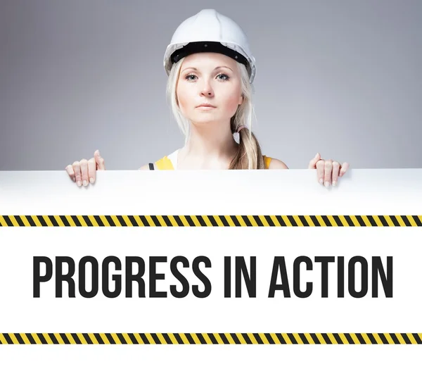 Worker holding progress in action sign on information board — Stock Photo, Image