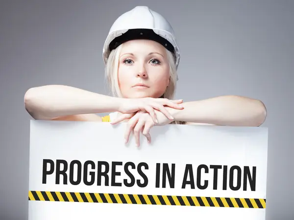 Trabalhador que detém progresso no sinal de ação no painel de informações — Fotografia de Stock