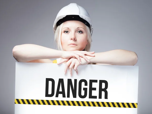 Worker holding danger sign on information board — Stock Photo, Image