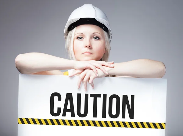 Trabalhador segurando sinal de cautela no painel de informações — Fotografia de Stock