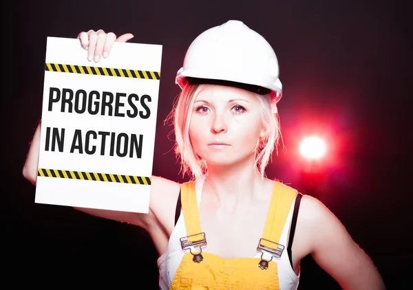 Postęp w działaniu Znak umieszczony na tablica informacyjna, pracownik kobieta — Zdjęcie stockowe