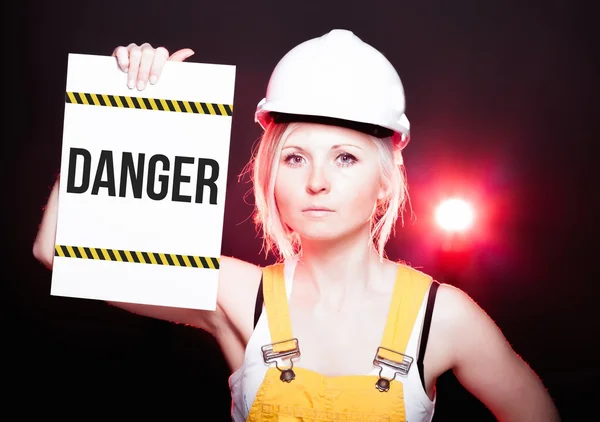 Nebezpečí znamení umístěné na informační tabuli, pracovník žena — Stock fotografie