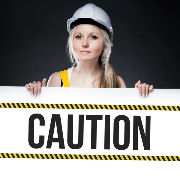 Señal de precaución en el tablero de plantillas, mujer trabajadora — Foto de Stock