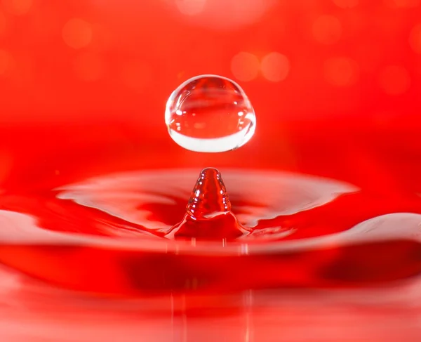 Wassertropfen Makro-Nahaufnahme, roter Hintergrund — Stockfoto
