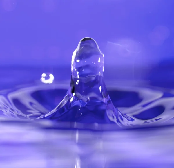 Vatten droppe makro närbild, blå bakgrund — Stockfoto