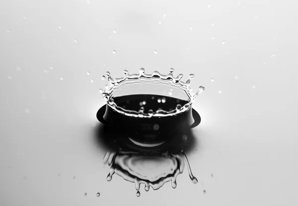 Acqua spruzzata da vicino con gocce, fondo grigio — Foto Stock