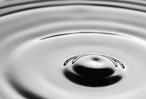 Acqua spruzzata da vicino con increspature, fondo grigio — Foto Stock
