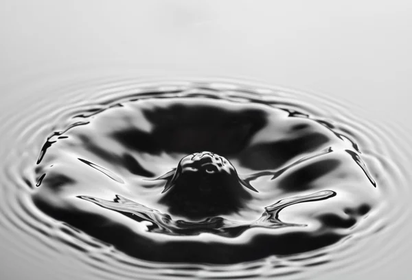 Respingo de água perto com ondulações, fundo cinza — Fotografia de Stock