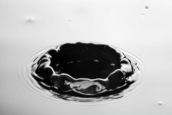 Respingo de água perto com ondulações, fundo cinza — Fotografia de Stock