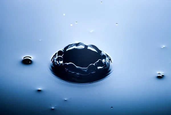 Salpicos de água perto com gotas, fundo azul — Fotografia de Stock