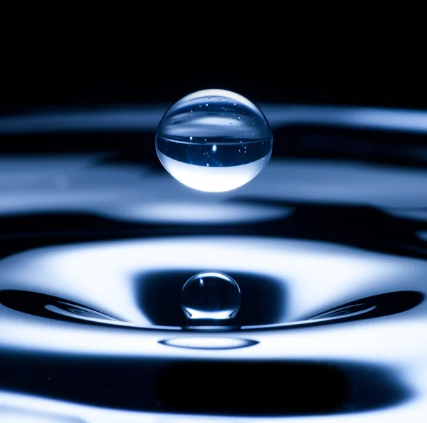 Gota de água voando de cima, cor azul — Fotografia de Stock