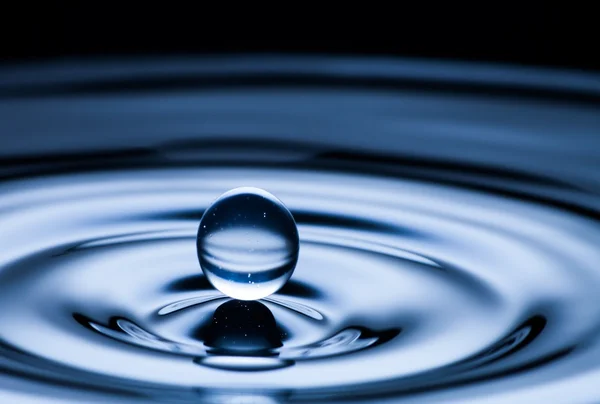 Gota de água e respingo de perto, cor azul escuro — Fotografia de Stock