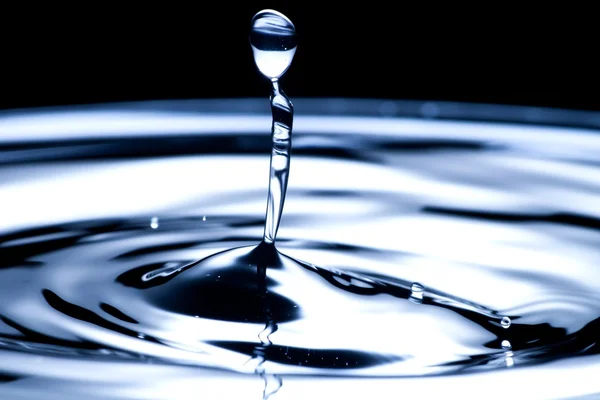 Gota de agua y salpicadura de cerca, color azul oscuro — Foto de Stock