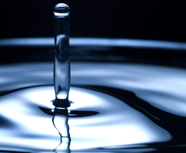 Gota de água e respingo de perto, cor azul escuro — Fotografia de Stock