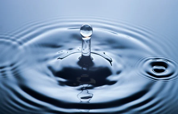 Gota de água de perto, fundo azul claro — Fotografia de Stock