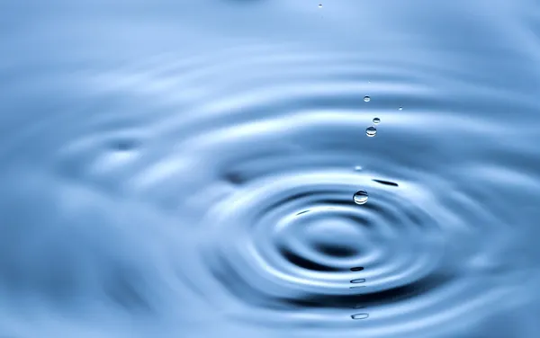Vattendroppe på nära håll, klar blå bakgrund — Stockfoto
