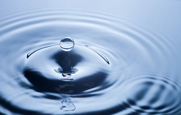 Gota de agua de cerca, fondo azul claro — Foto de Stock