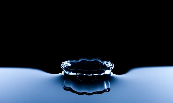 Vesi roiske makro, tummansininen tausta — kuvapankkivalokuva