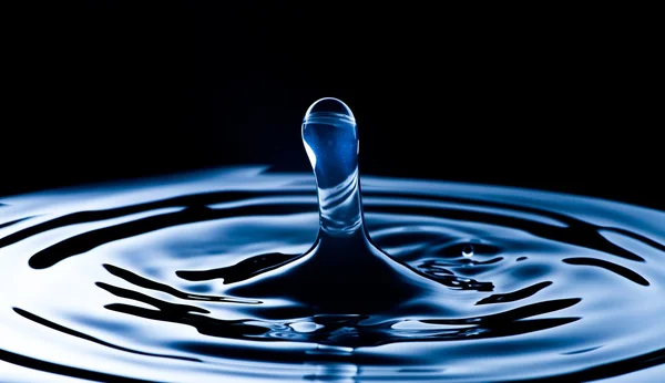Acqua spruzzata macro, sfondo blu scuro — Foto Stock